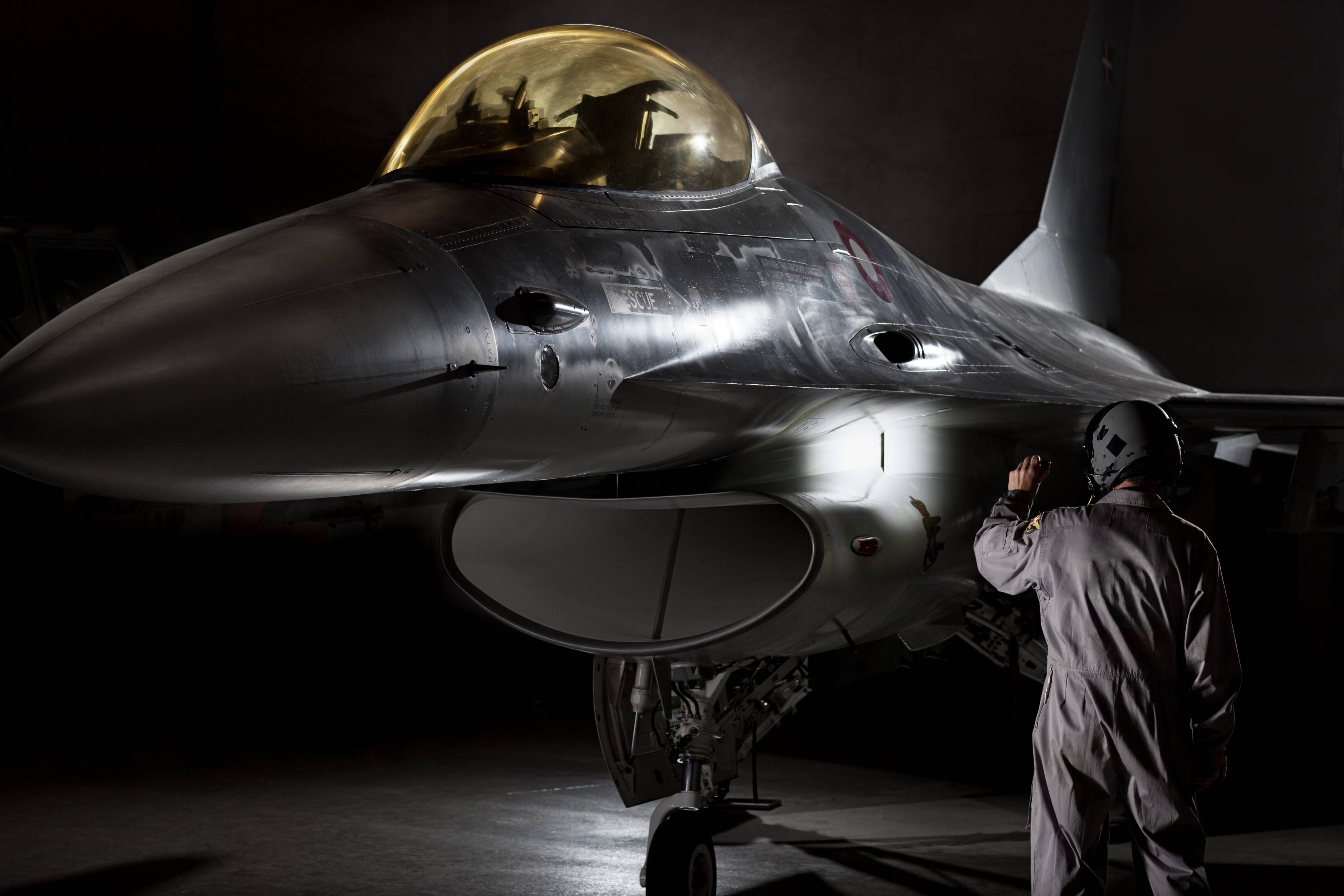 F16 fighter pilot inspecting his airplane with professional Suprabeam flashlight