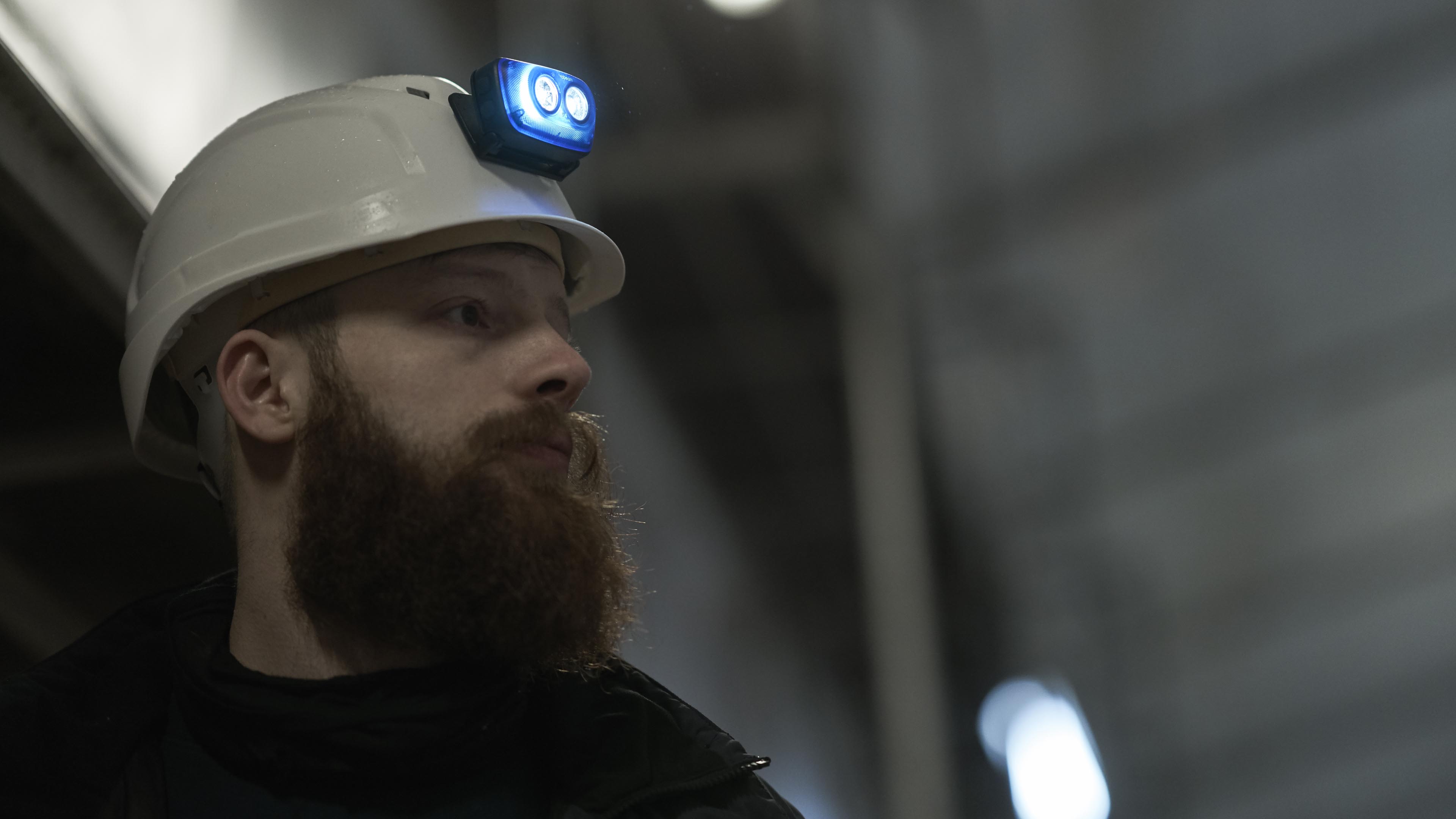 Electrician with helmet mounted headlamp Electrician working on a construction site, with a S4 rechargeable headlamp mounted on his safety helmet