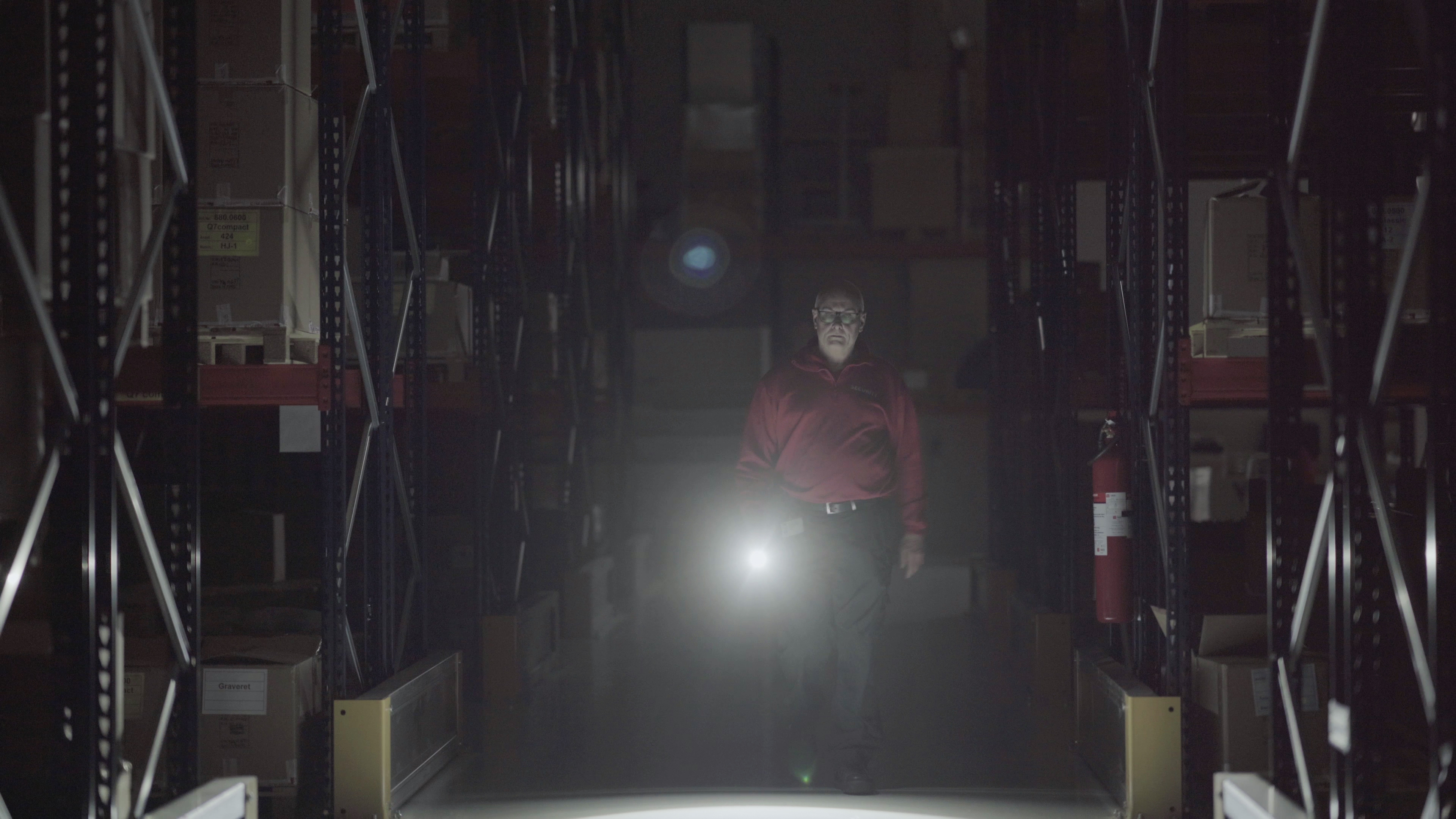 Security guard Security guard inspecting warehouse at night