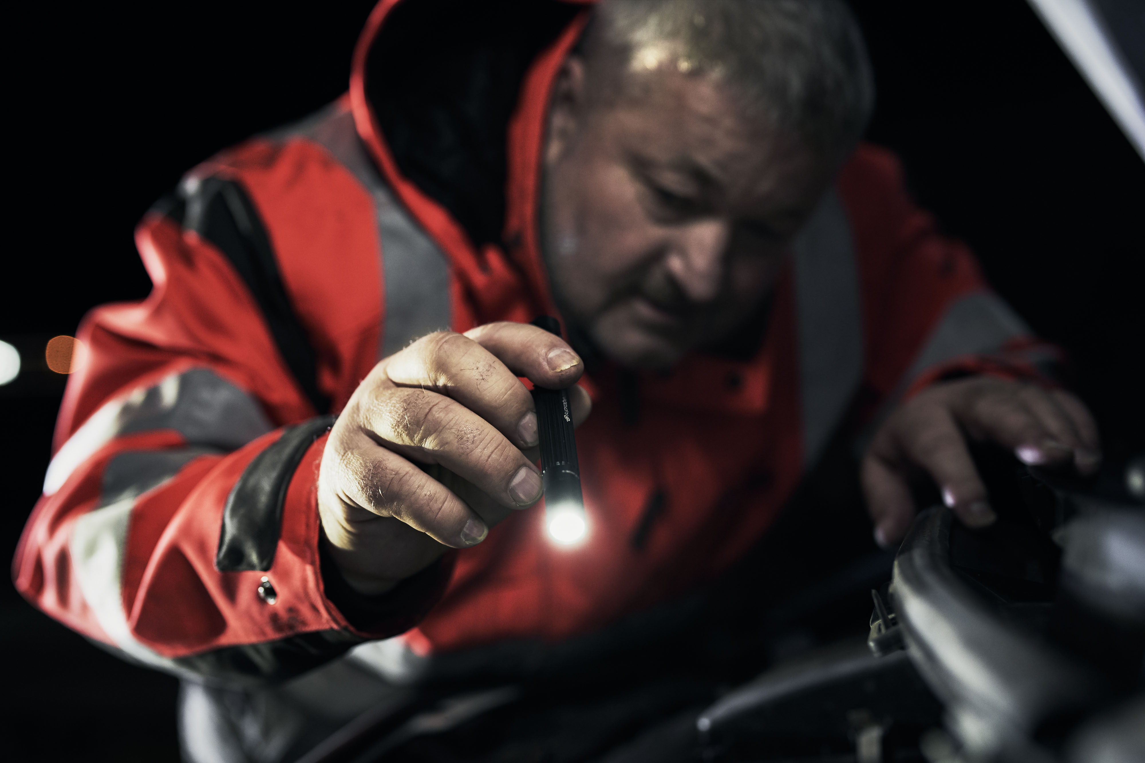 roadside_assistance_10 Roadside assistance offier working with headlamp